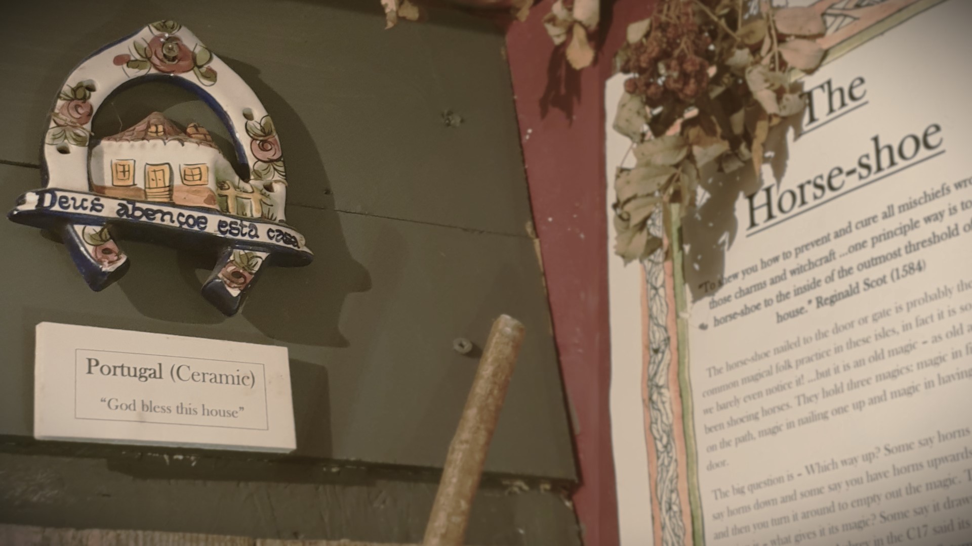 A photo of a ceramic horseshoe exhibited next to a museum label detailing the history of horseshoes.